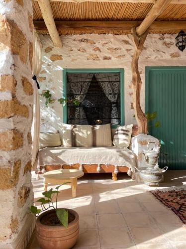 a living room with a couch and a stone wall at Berber Beldi Camp in Imsouane