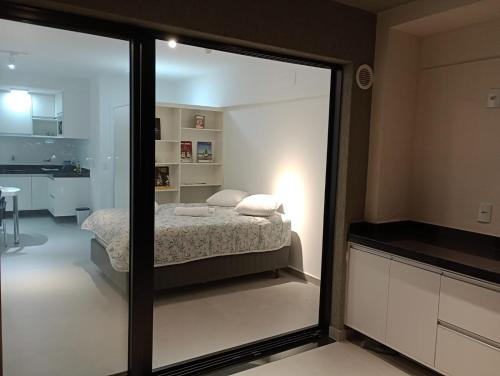 a bedroom with a bed and a large glass window at Studio 811 in Marília