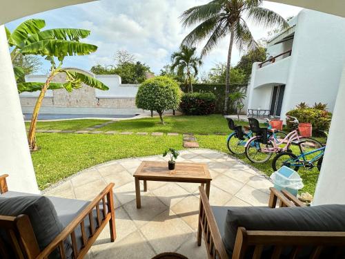 eine Terrasse mit Stühlen, einem Tisch und einem Hof in der Unterkunft Villa Vaoli in Playa del Carmen