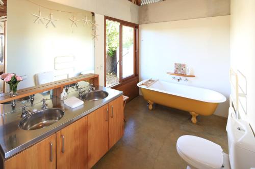 een badkamer met 2 wastafels en een bad bij The Pah in Onetangi