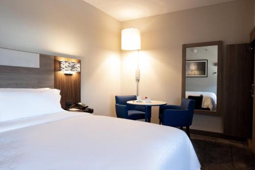 a hotel room with a bed and a table and a mirror at Holiday Inn Express Mexico City Satelite, an IHG Hotel in Mexico City