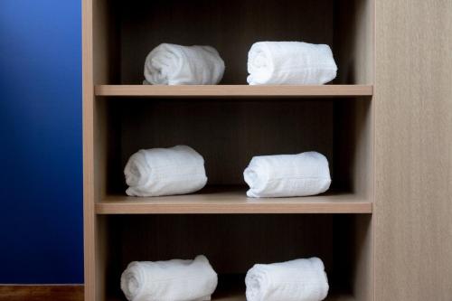 four rolls of toilet paper sitting on a shelf at Holiday Inn Express Mexico City Satelite by IHG in Mexico City