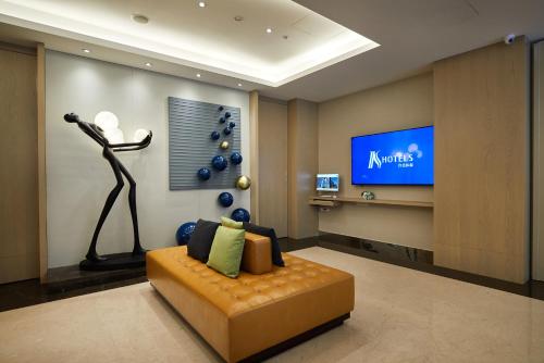 a living room with a couch and a tv at K Hotels Taipei Linsen in Taipei