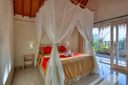 Schlafzimmer mit einem Bett mit Moskitonetz in der Unterkunft Cassava Penida Cottage in Nusa Penida