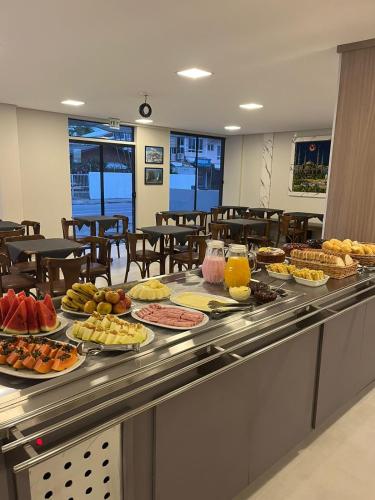 een buffet met veel verschillende soorten eten bij Monte Libano Apart Hotel in Florianópolis