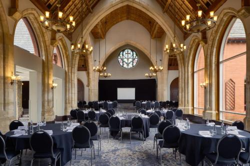 a conference room with tables and chairs in a building at Holiday Inn Bolton Centre by IHG in Bolton