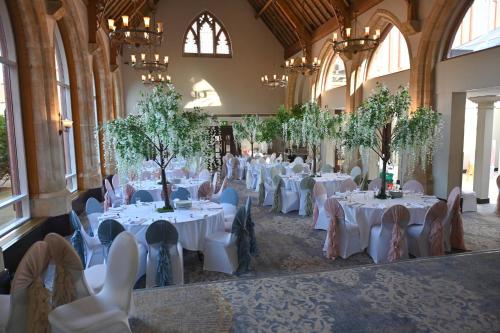 a banquet hall with white tables and chairs at Holiday Inn Bolton Centre by IHG in Bolton