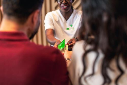 a woman holding a green object in a group of people at Holiday Inn & Suites - Dubai Science Park by IHG in Dubai