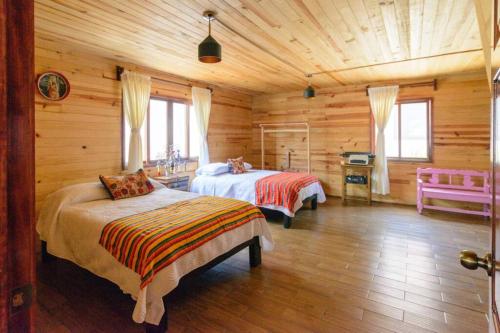 um quarto com 2 camas num chalé de madeira em Alma y Paz. Cabaña & Casa em Comitán de Domínguez