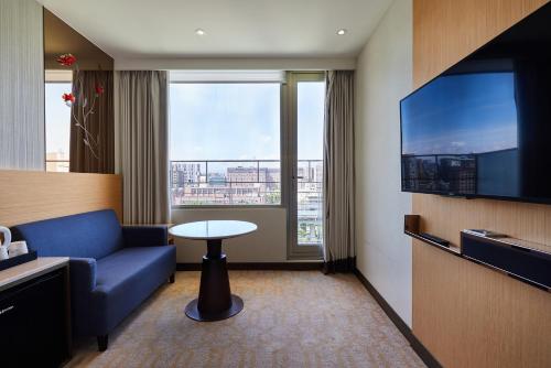 a hotel room with a blue couch and a table at K Hotel Tianjin in Taipei