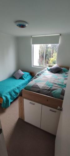 a bedroom with two beds and a window at Acogedor Apartamento Constitucion in Constitución