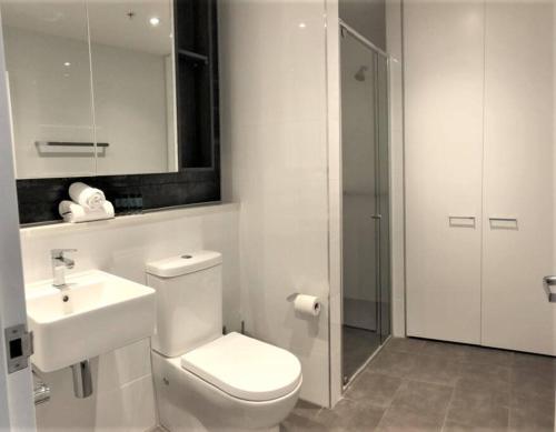 a bathroom with a toilet and a sink and a shower at Serain Residences on 88 Archer Chatswood in Sydney