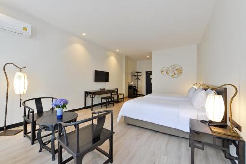 a hotel room with a bed and a table and chairs at Oldthaiheng Hotel in Bangkok