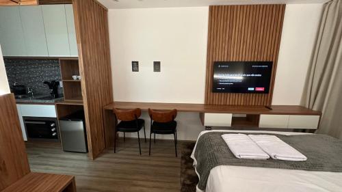 a hotel room with a bed and a desk with a television at Moov 2415 Studio Mooca in Sao Paulo