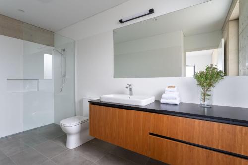 a bathroom with a sink and a toilet and a mirror at The Duke I Private Properties in Gnarabup