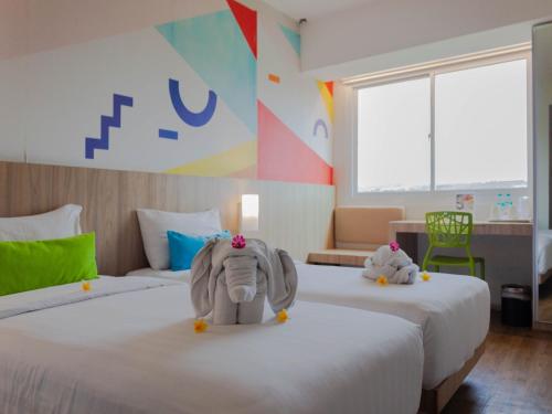 a room with two beds with a stuffed elephant on them at Zuri Express Jimbaran in Jimbaran