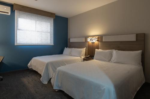 a hotel room with two beds and a window at Holiday Inn Express Morelia Centro Historico in Morelia