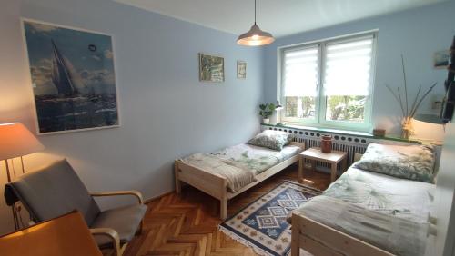 a living room with a couch and a window at Captain's Cottage 110m2, near Sopot, beaches, with a garden, grill & free parking in Gdańsk