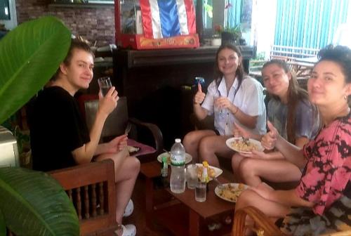 a group of people sitting around a table drinking wine at Srikrung Guesthouse in Phra Nakhon Si Ayutthaya