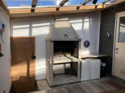 an outdoor oven in a garage with a roof at Cómoda y amplía casa con Quincho in Punta Arenas