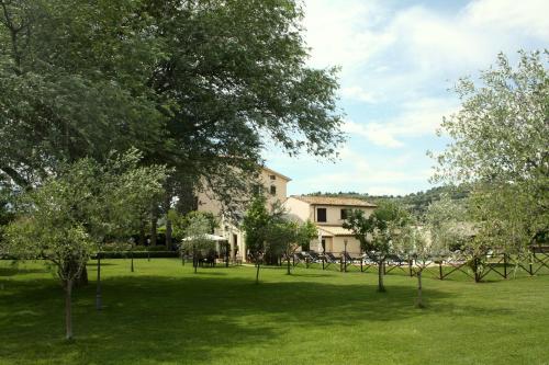 a green field with trees in front of a building at Residenza Porta Guelfa in Bevagna