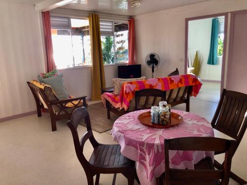 a living room with a table with a pink table cloth at Fare Mirimiri in Uturoa