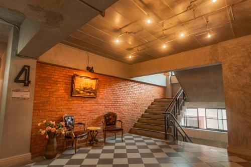 a lobby with a staircase and a brick wall at The Old Inn in Udon Thani