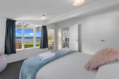 a bedroom with a bed with a view of the ocean at The Middle in Rotoiti