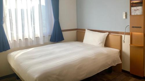 Кровать или кровати в номере Toyoko Inn Hokkaido Hakodate Ekimae Daimon