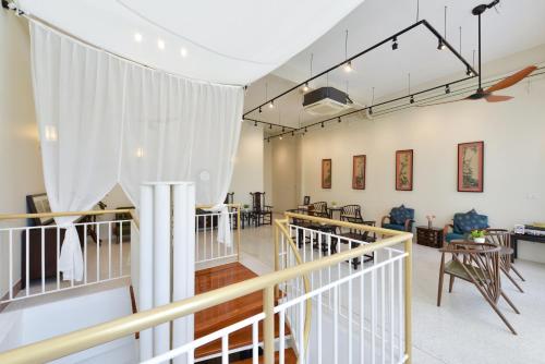 a large room with a staircase and tables and chairs at Oldthaiheng Hotel in Bangkok