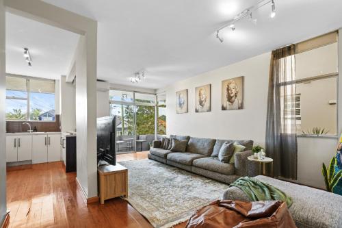 a living room with a couch and a tv at Sunny Bondi Retreat: Beach & Culture Unite! in Sydney