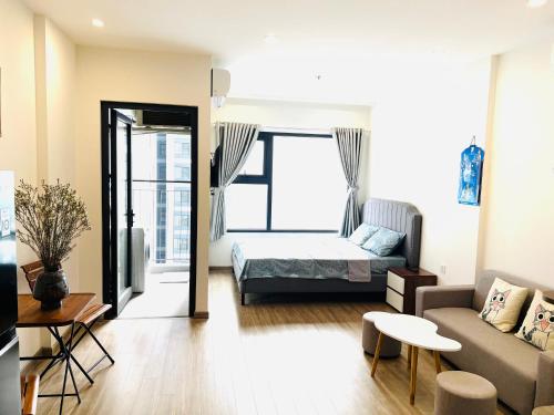 un salon avec un canapé et un lit dans l'établissement Studio Luxury Sakura - Vinhome Smart city Mỹ Đình, à Hanoï