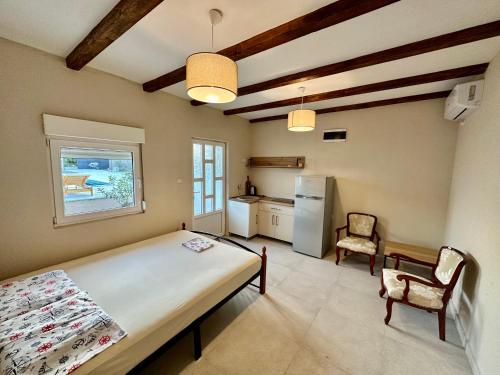 Un dormitorio con una cama grande y una cocina. en Sunny village, pool house, en Podgorica