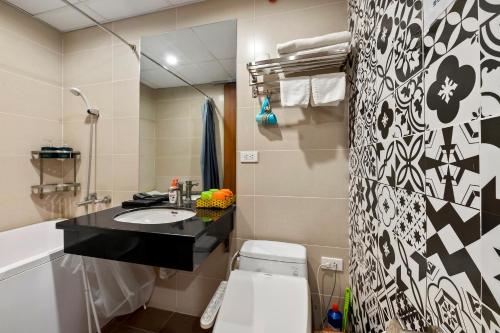 a bathroom with a sink and a toilet and a mirror at 22Housing luxury Hotel & Residence 39 Linh Lang in Hanoi