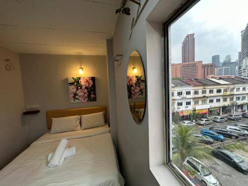 um pequeno quarto com uma cama e uma janela em DingDong Bukit Bintang Luxury Suites,3mi to PaVlion mall em Kuala Lumpur