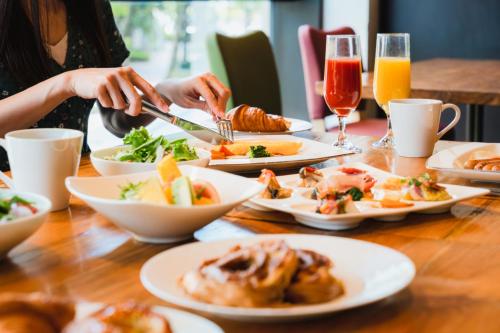 a table with plates of food and glasses of orange juice at Hotel Nikko Kanazawa in Kanazawa