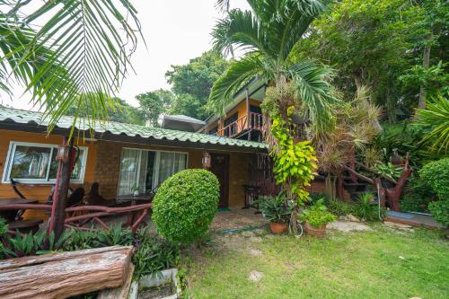 a house with palm trees in front of it at Tongta Phaview Resort in Ko Samed