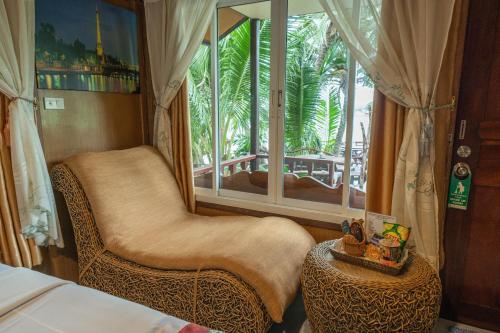 a bedroom with a chair and a large window at Tongta Phaview Resort in Ko Samed