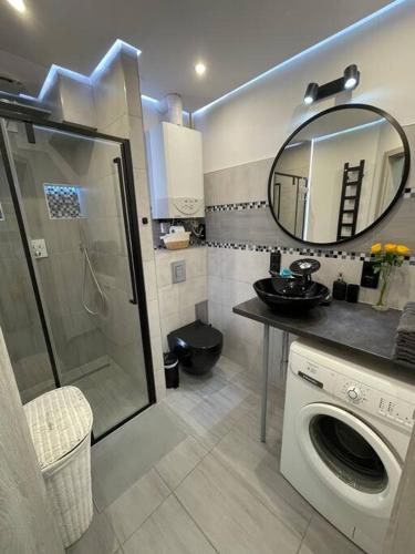 a bathroom with a washing machine and a mirror at Apartament 20 in Radków