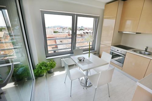 a kitchen with a white table and chairs and a window at City Hotel Nitra with free parking in Nitra