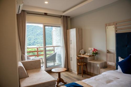a hotel room with a bed and a balcony at Hotel Adam in Pokhara