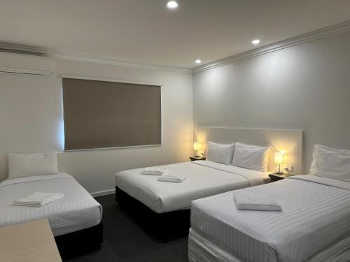 ein Hotelzimmer mit 2 Betten und einem Bildschirm in der Unterkunft Golf View Motel in Sanctuary Point