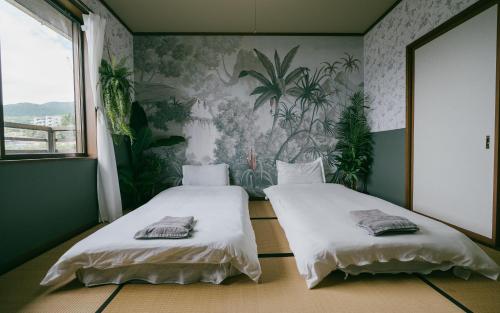 two beds in a room with plants on the wall at 森の中富士山見える部屋202 in Hakone