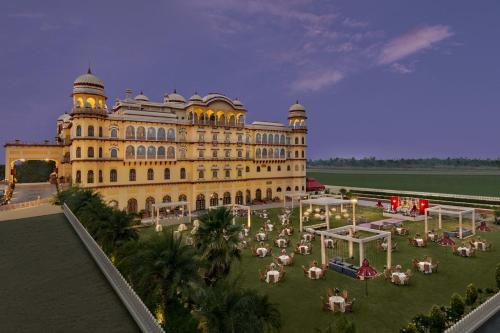 a large yellow building with a garden in front of it at Noormahal Palace Hotel in Karnāl