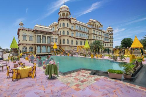 a large building with a pool in front of it at Noormahal Palace Hotel in Karnāl