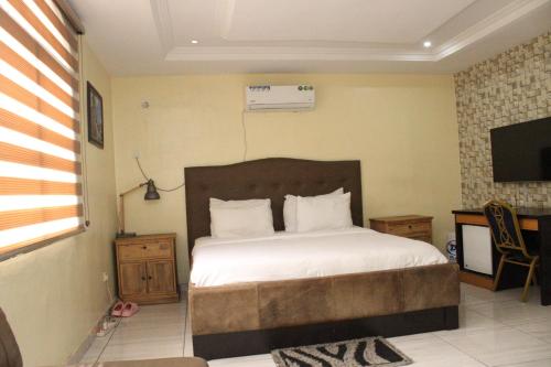 a bedroom with a large bed and a television at MITOS LUXURY SUITES (ANNEX) in Lagos