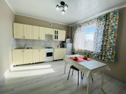 科克舍陶的住宿－2.х полноценная . ЖК комфорт.，厨房配有白色橱柜、桌子和窗户。