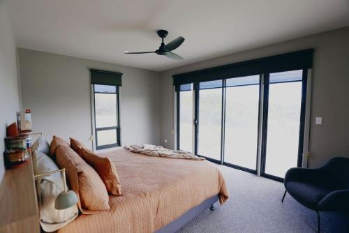 a bedroom with a bed and a ceiling fan at Stony Rise Lodge in Robe