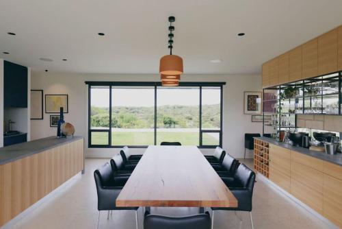 uma grande sala de jantar com uma mesa longa e cadeiras de couro em Stony Rise Lodge em Robe