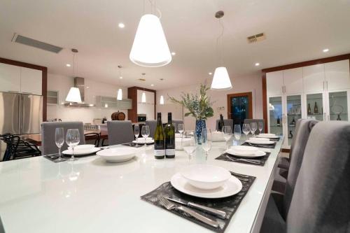 a large white table with plates and wine glasses at The Hideaway by Gatt Wines in Craneford